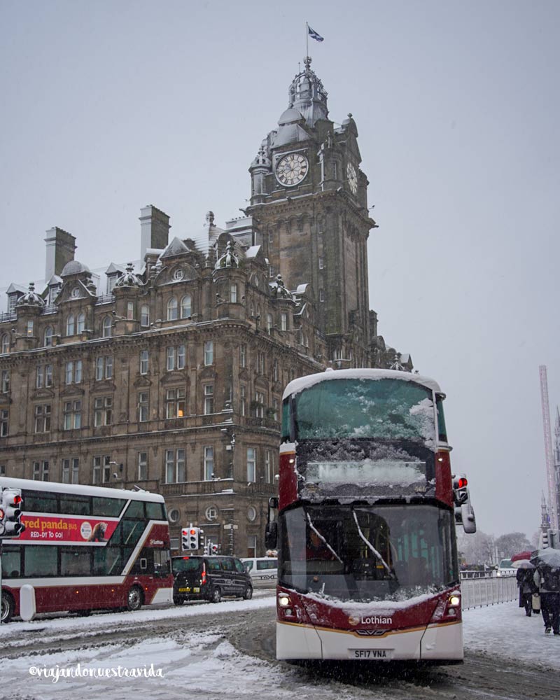 como ir delaeropuerto de Edimburgo al centro Autobús Airlink de Lothian Buses circulando por una calle nevada del centro de Edimburgo rumbo al aeropuerto.